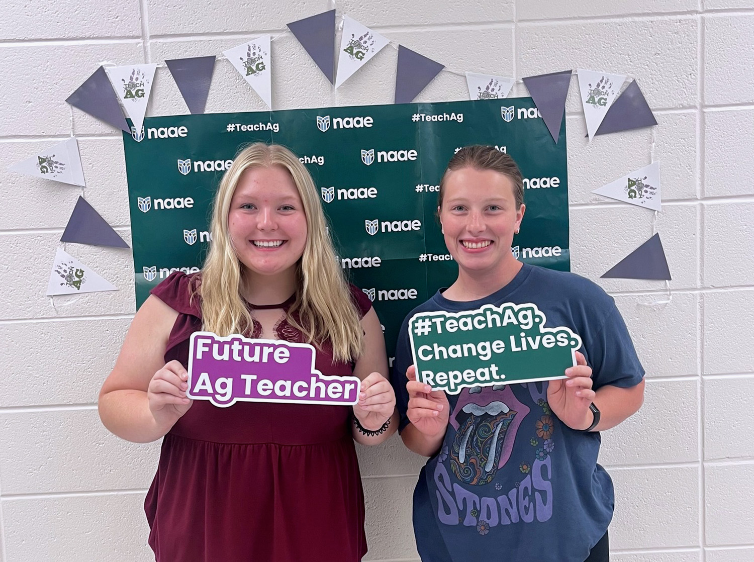 Two female students pose with signs saying "Future Ag Teacher"