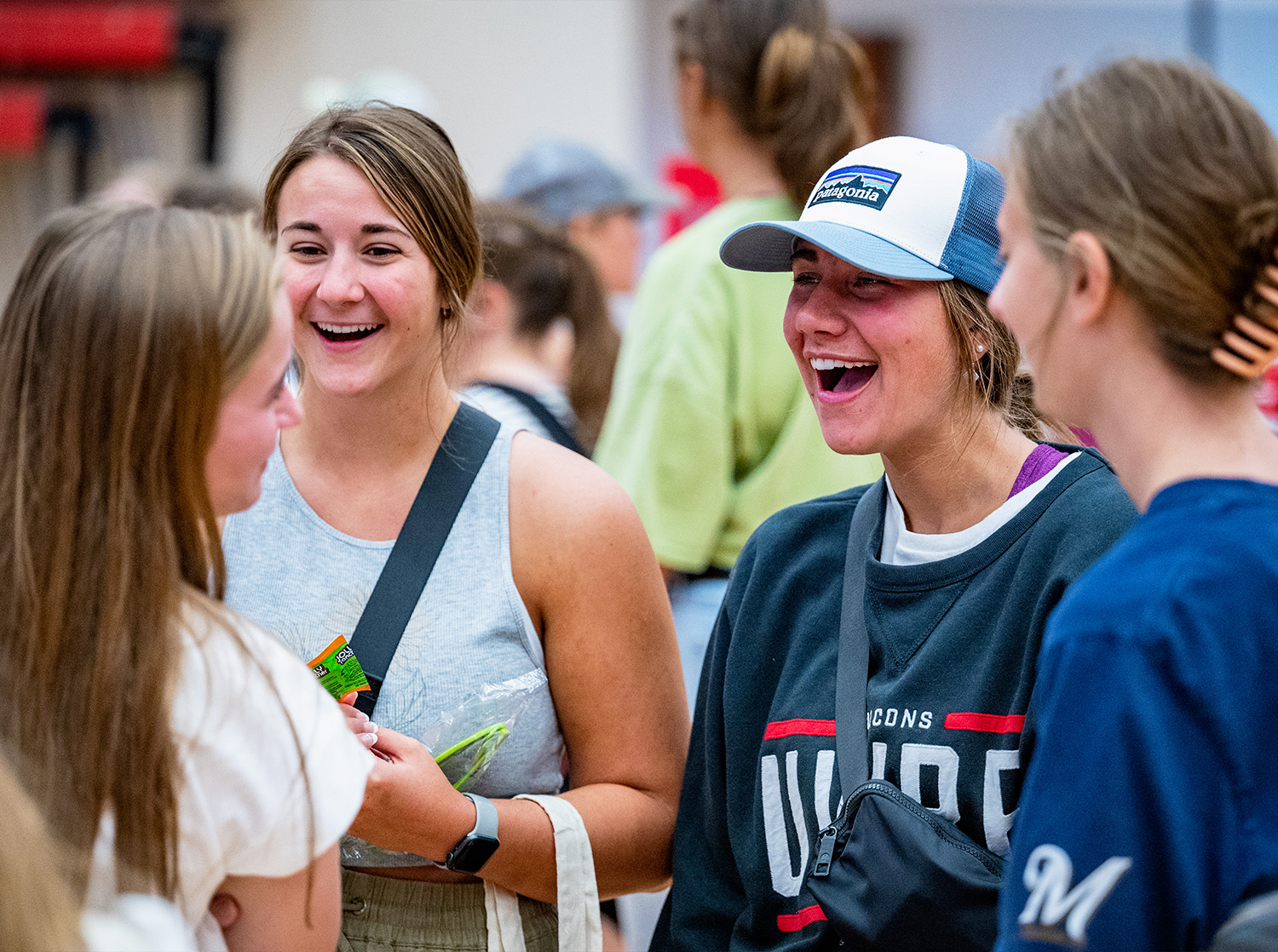 A group of women laugh together at the Involvement Fair in the Falcon Center