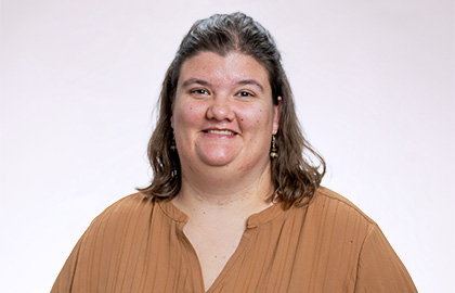 Headshot of Becca Jazdzewski, a young woman with short brown hair wearing a tan blouse