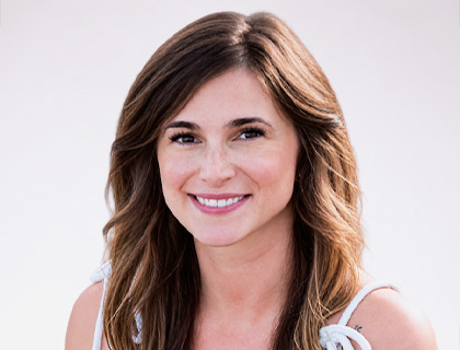 Headshot of Brieanna Watters, a young woman with long brown hair wearing a white tank top