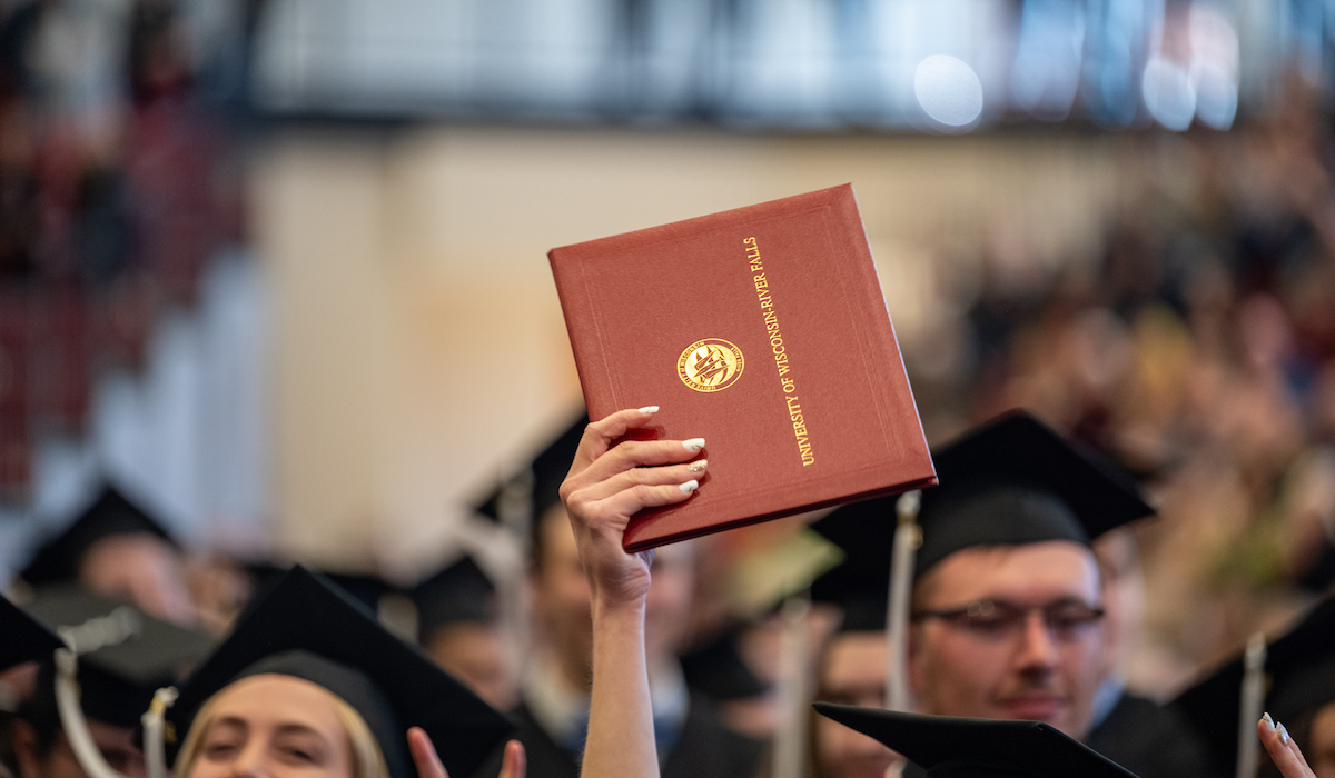 a graduate holds a diploma in the air
