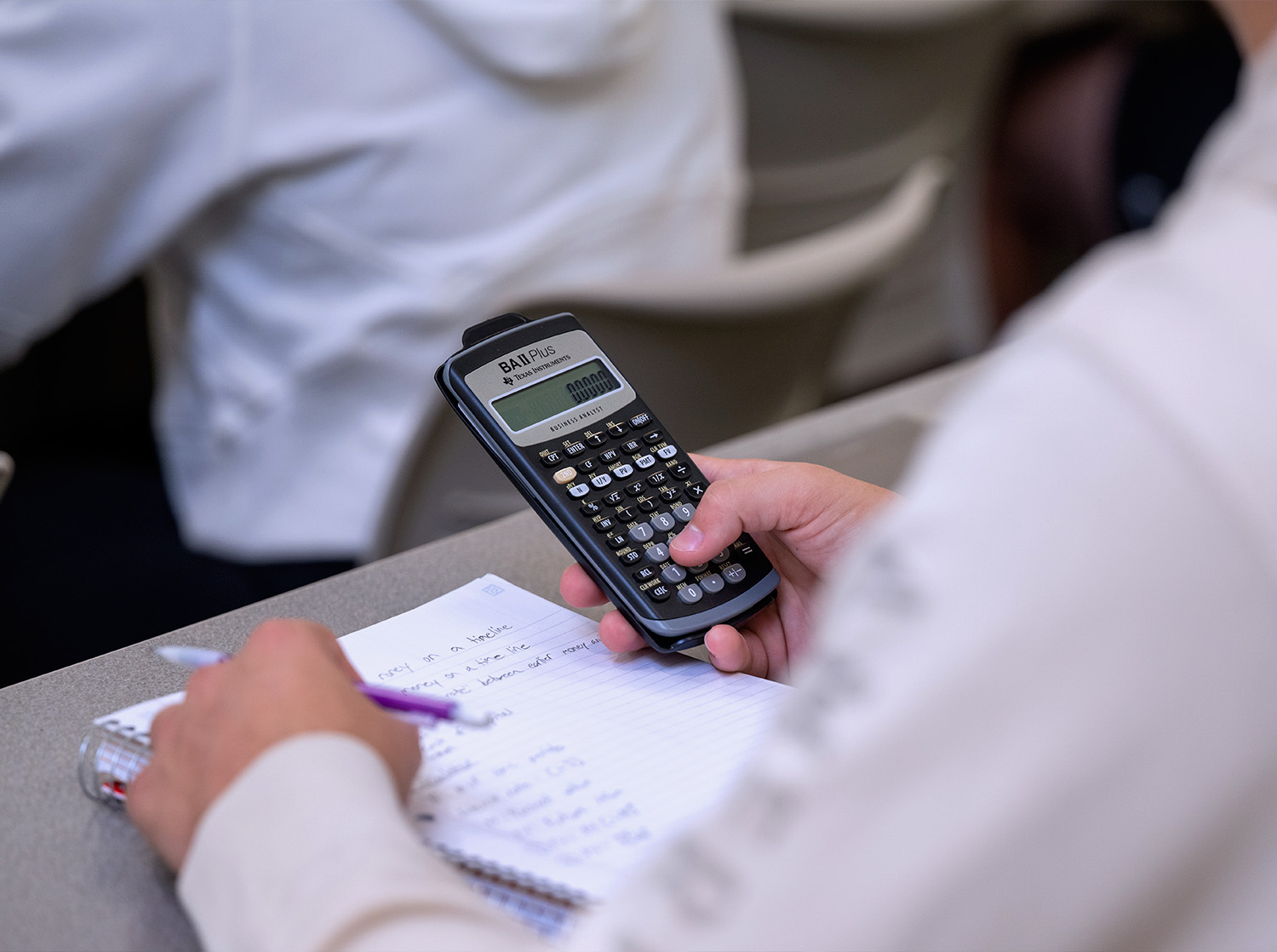 A student holds a calculator during class