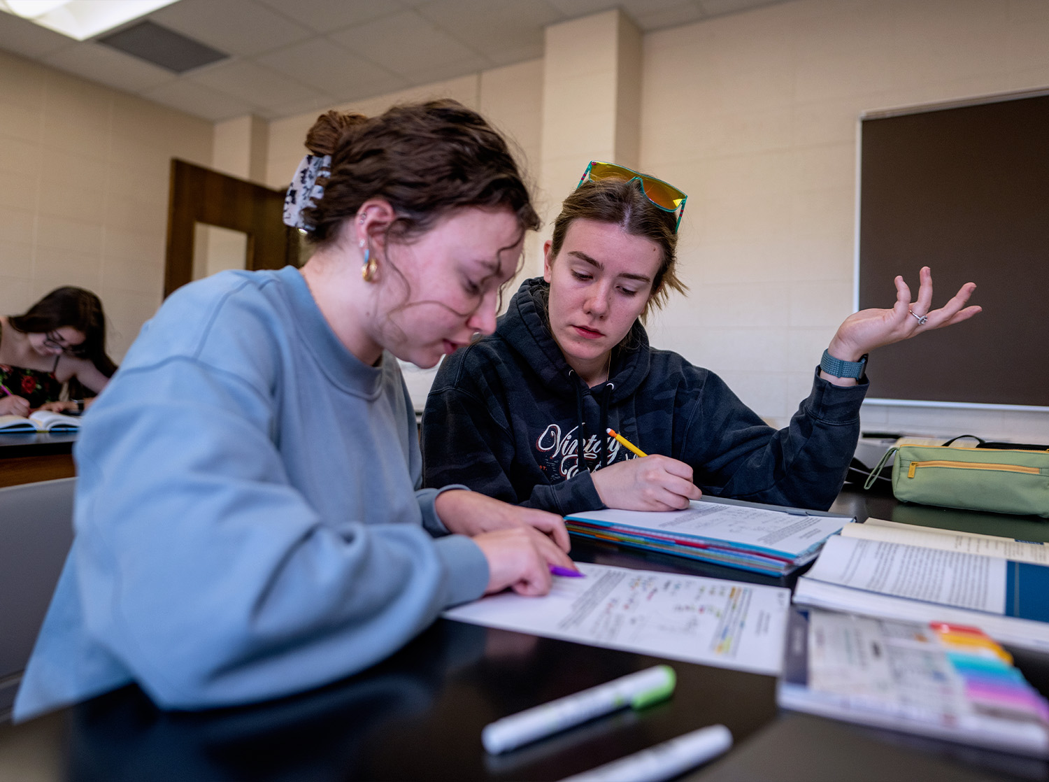 Two female students work on an exercise during class