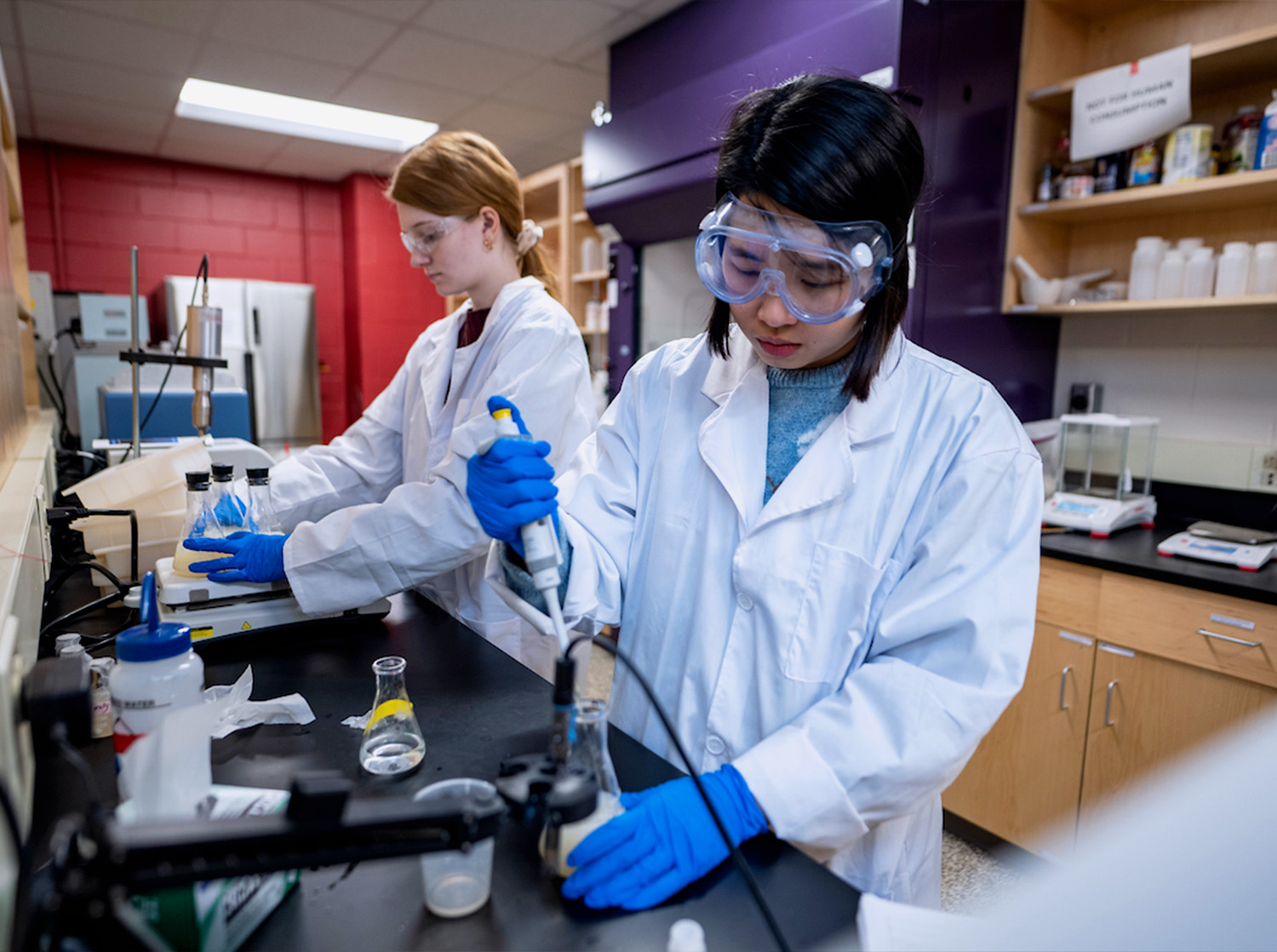Two female students work in a biology lab running experiments
