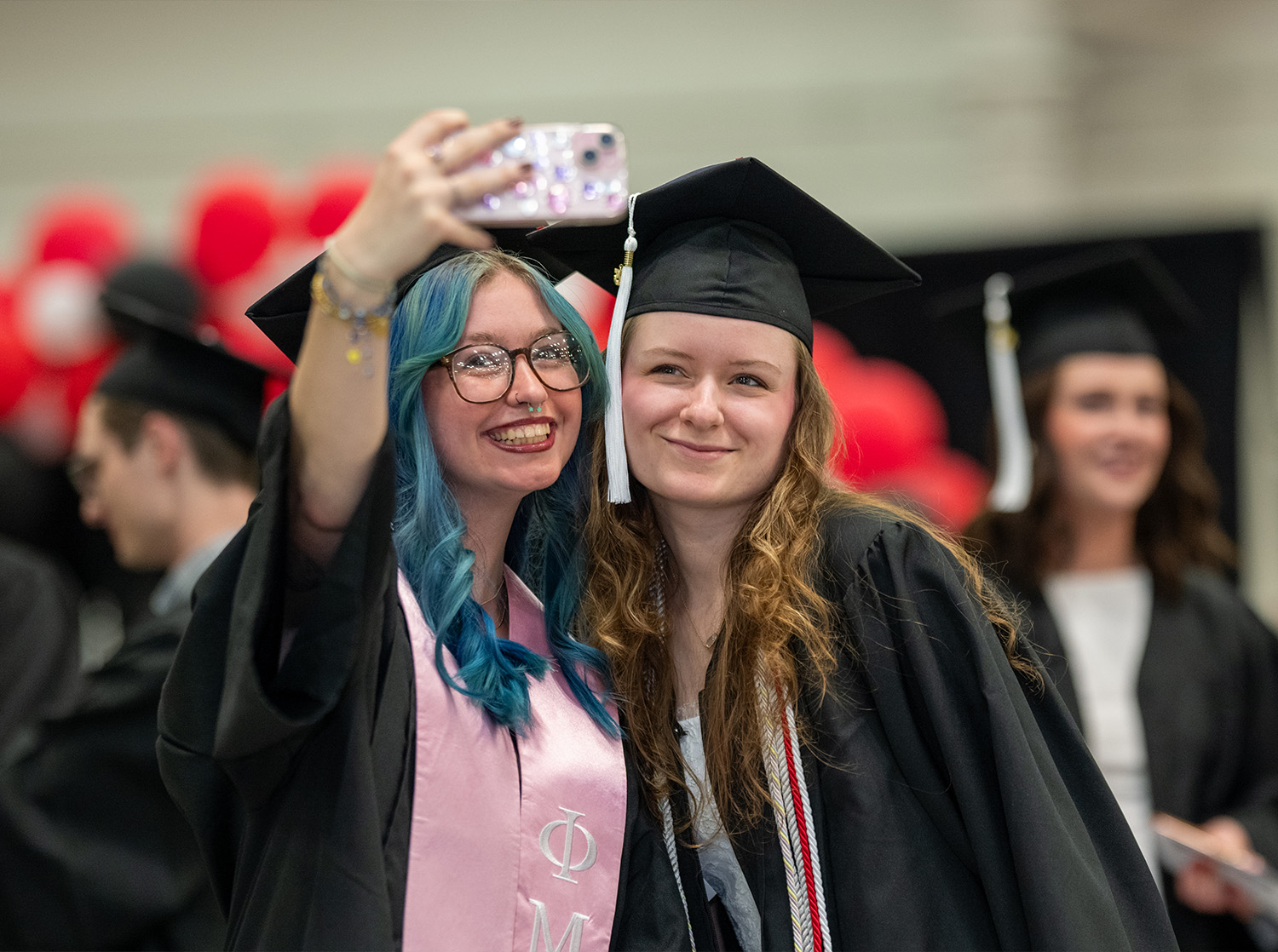 Two female students take a selfie before the CAS commencement ceremony