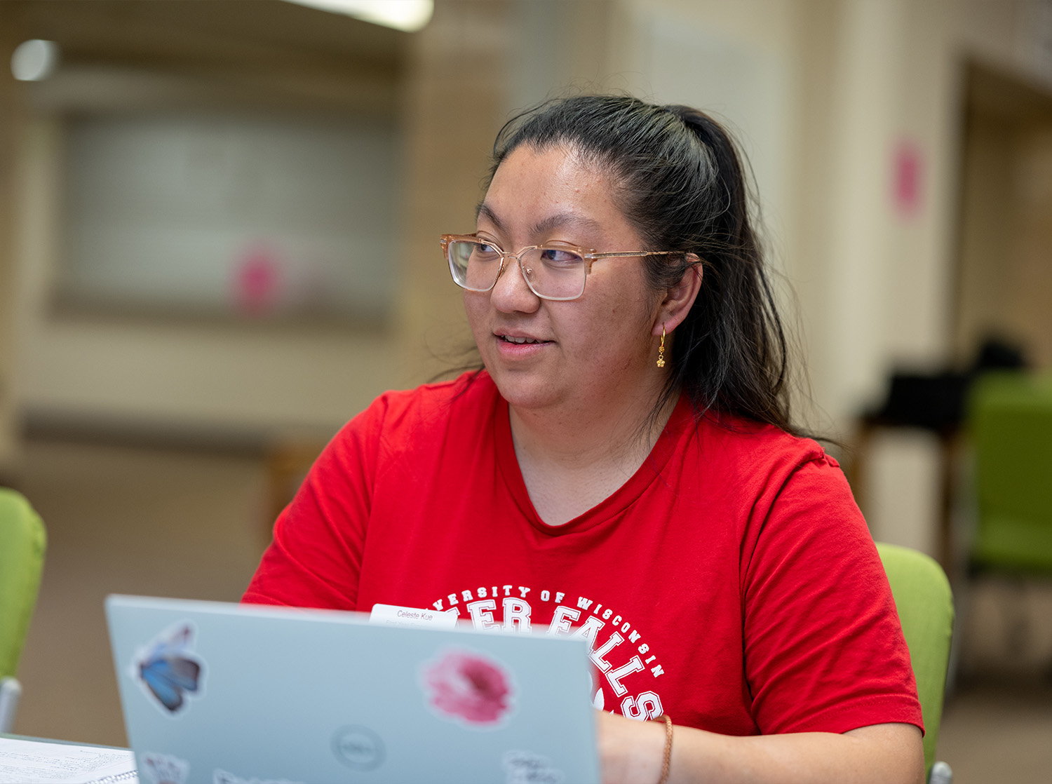 A female student works on their laptop during a marketing class