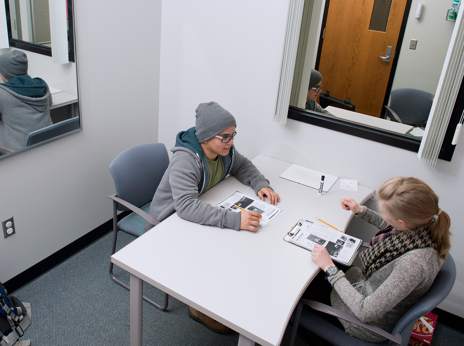 A male and female student sit across from each other at a table