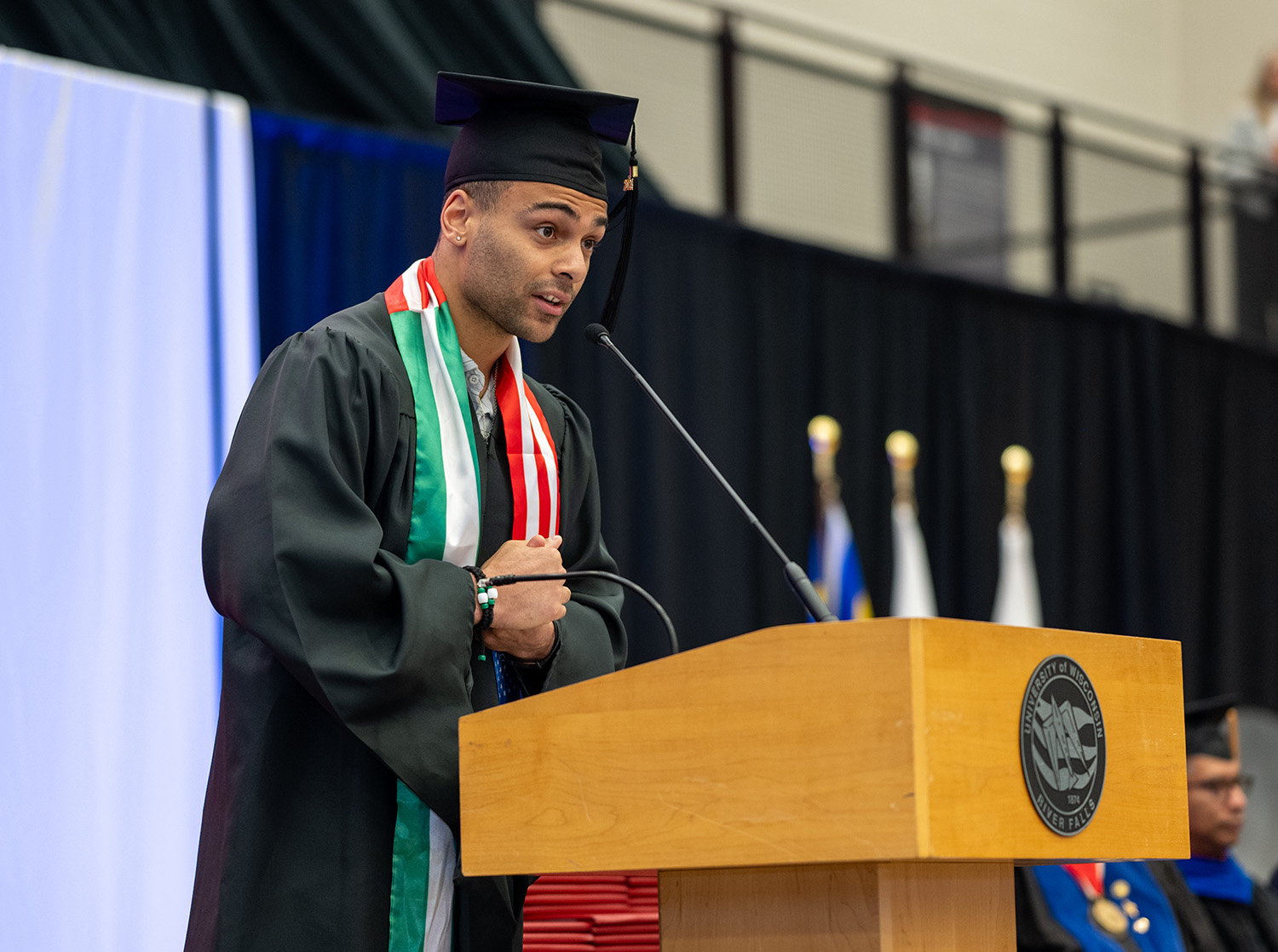 A student speaker addresses the graduates at the commencement ceremony in Page Arena