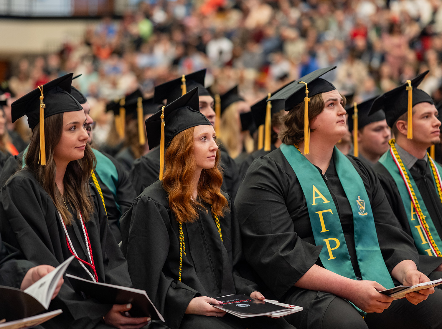 Graduates listen intently to the student speaker at commencement in Page Arena