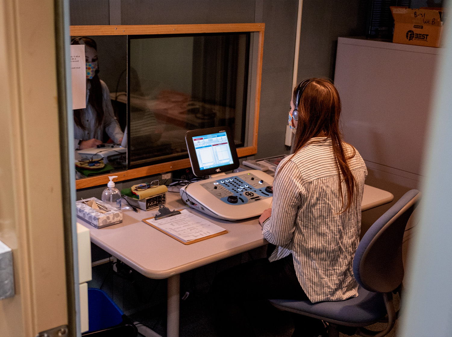 A student uses an audio device to test the hearing of another student