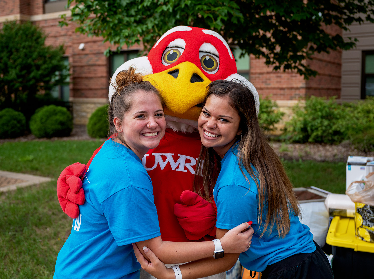 Two students hugging Freddy Falcon during Move-In Day