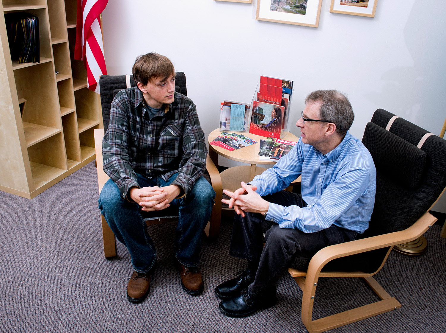 A professor sits with a student during a 1-on-1 meeting