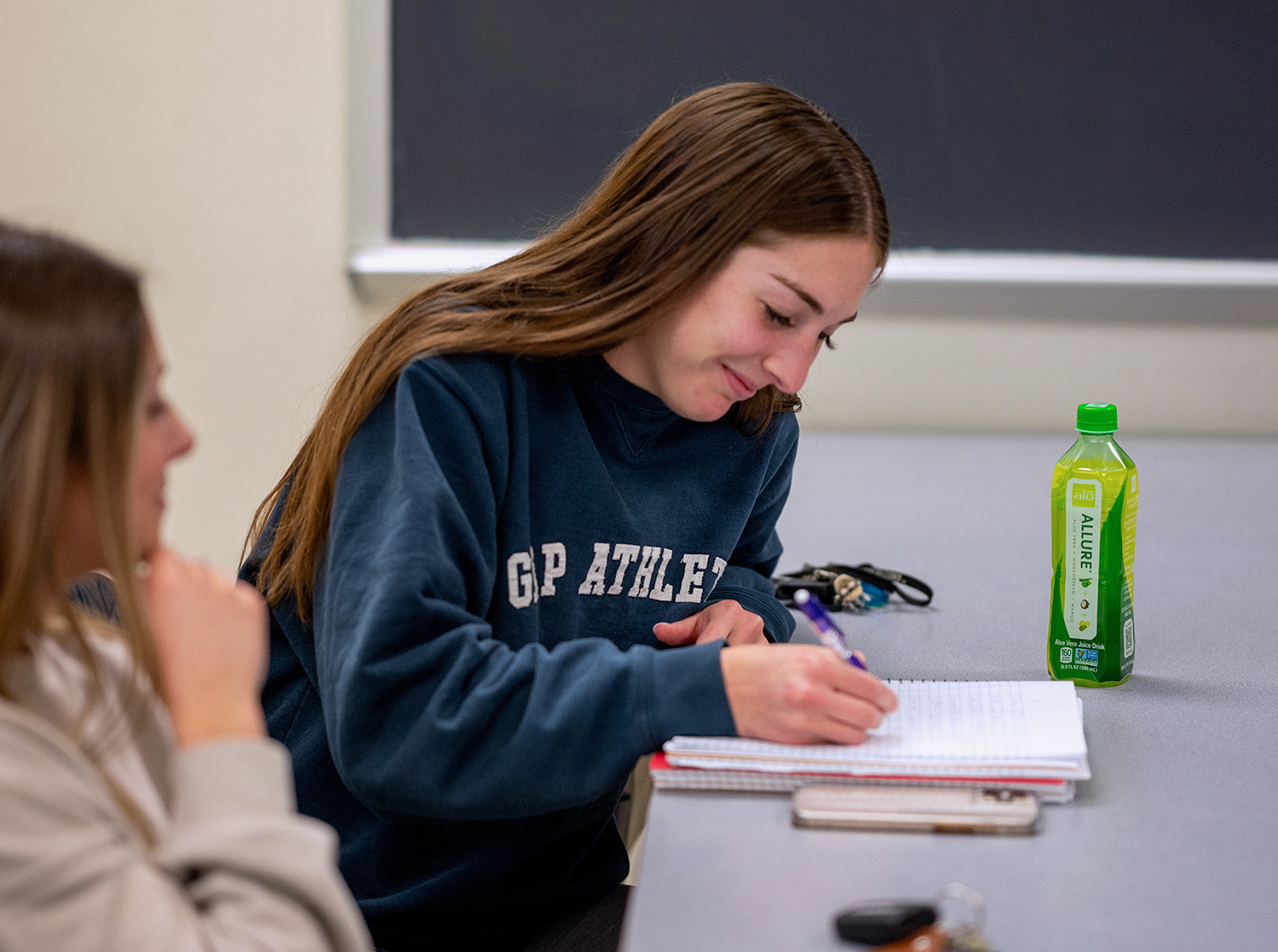 A female student takes notes during an economics class