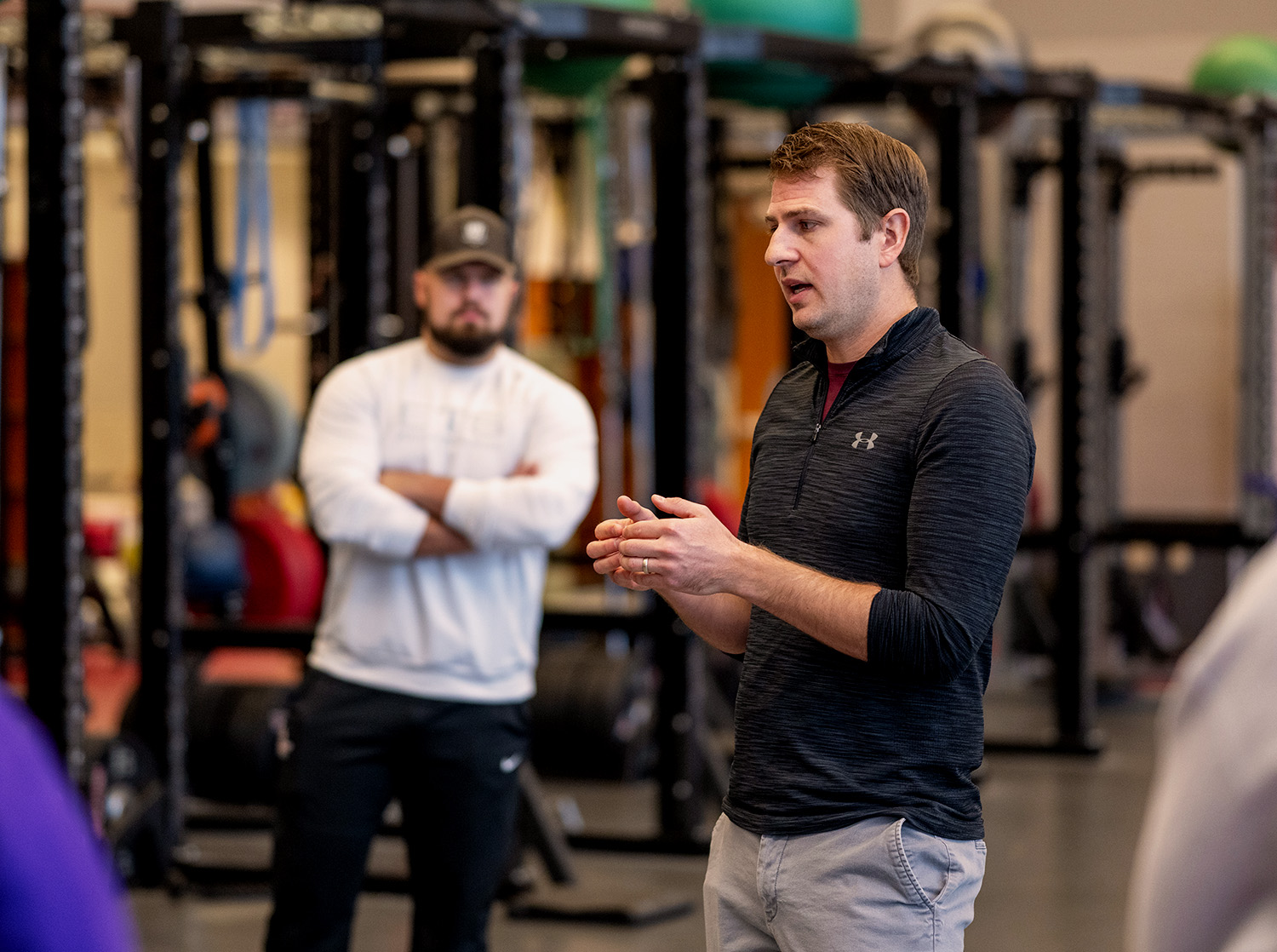 Professor speaks to a group of Health and Human Performance students in the Falcon Center weight room 