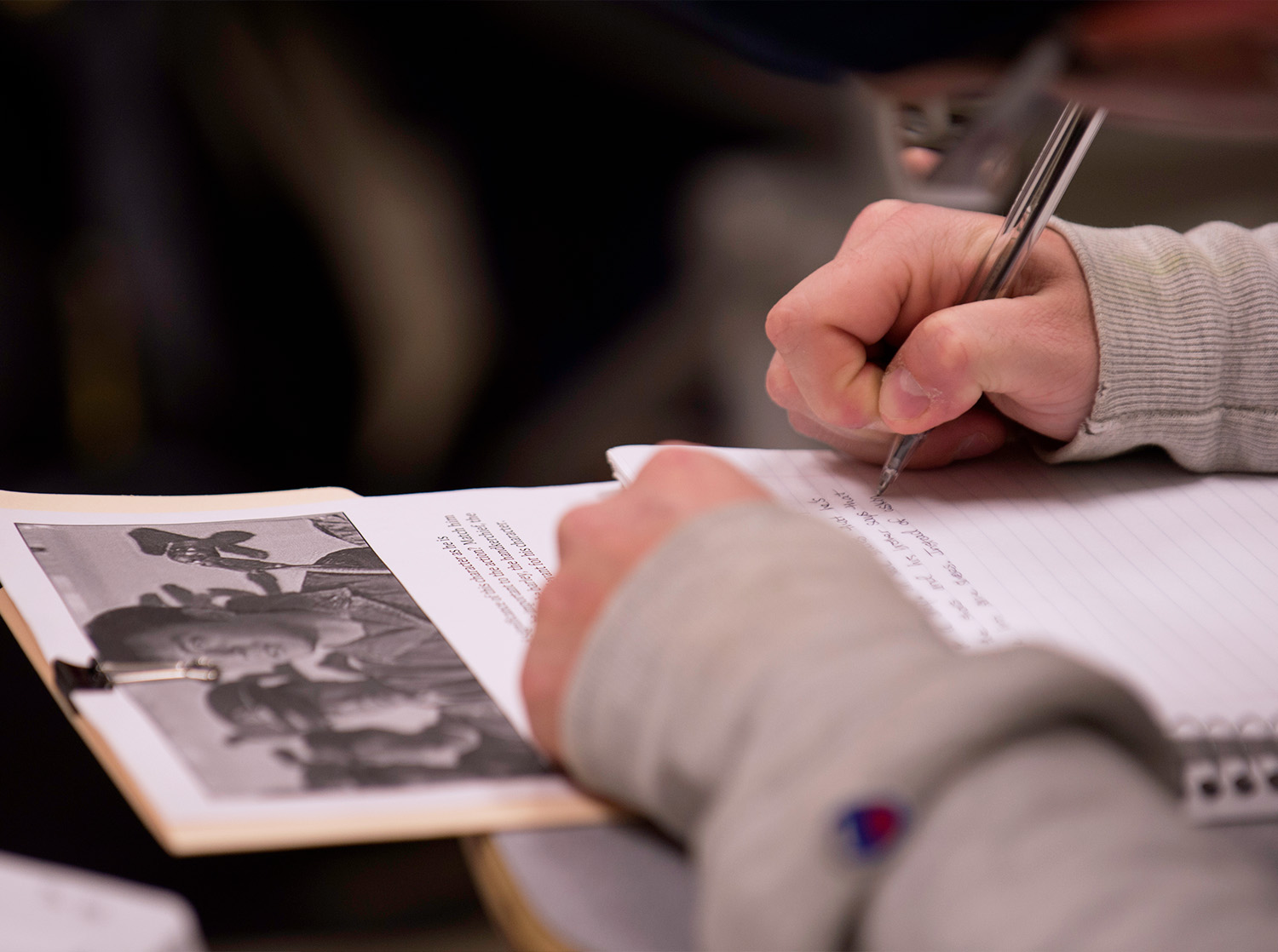 A student writes their notes in a notebook