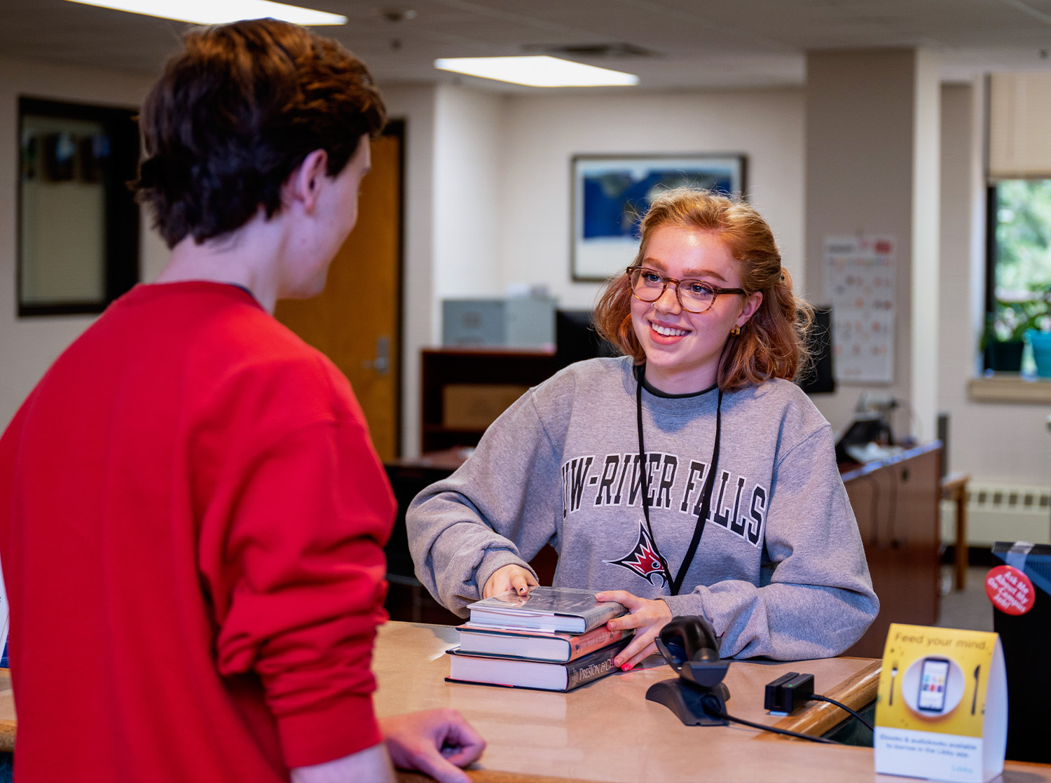 A student checks out books from the Library on campus