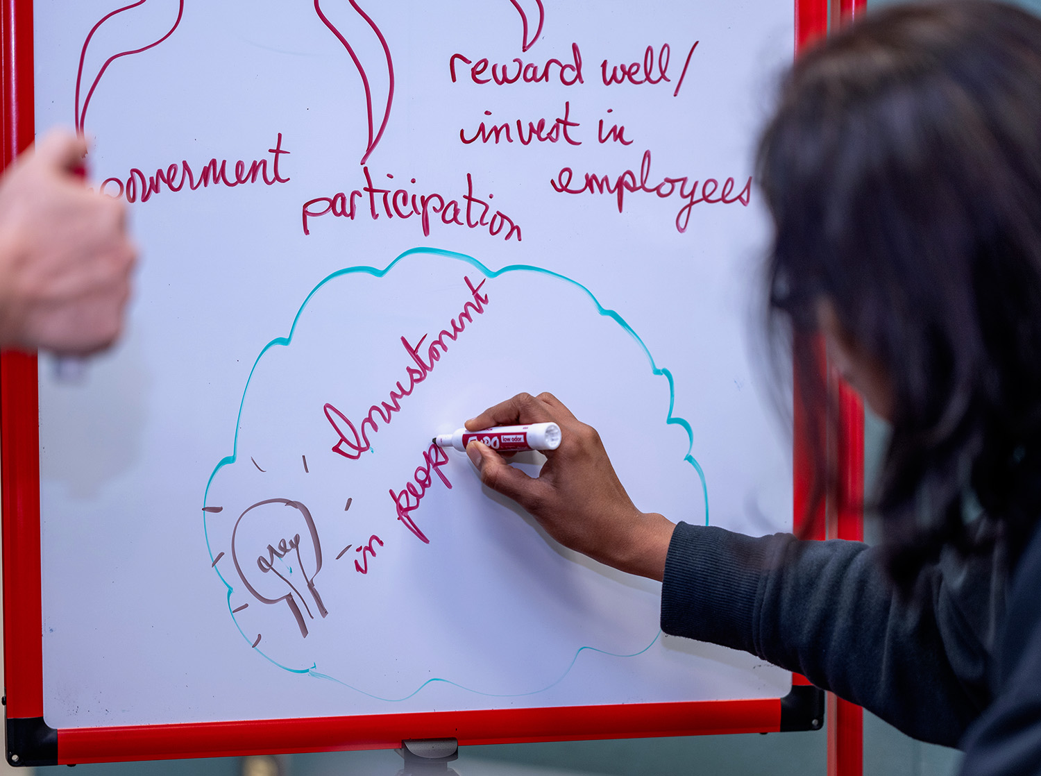 A female student writes on a portable whiteboard