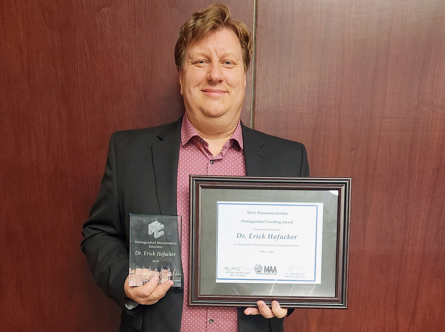 Professor Erick Hofacker shows off his Distinguished Teaching Award