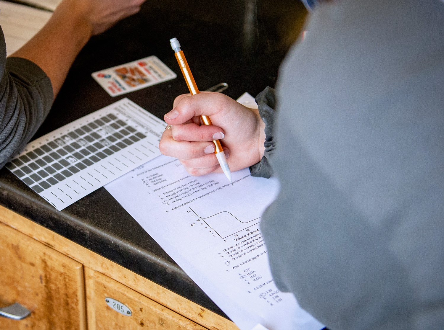 A person works on a paper worksheet during class