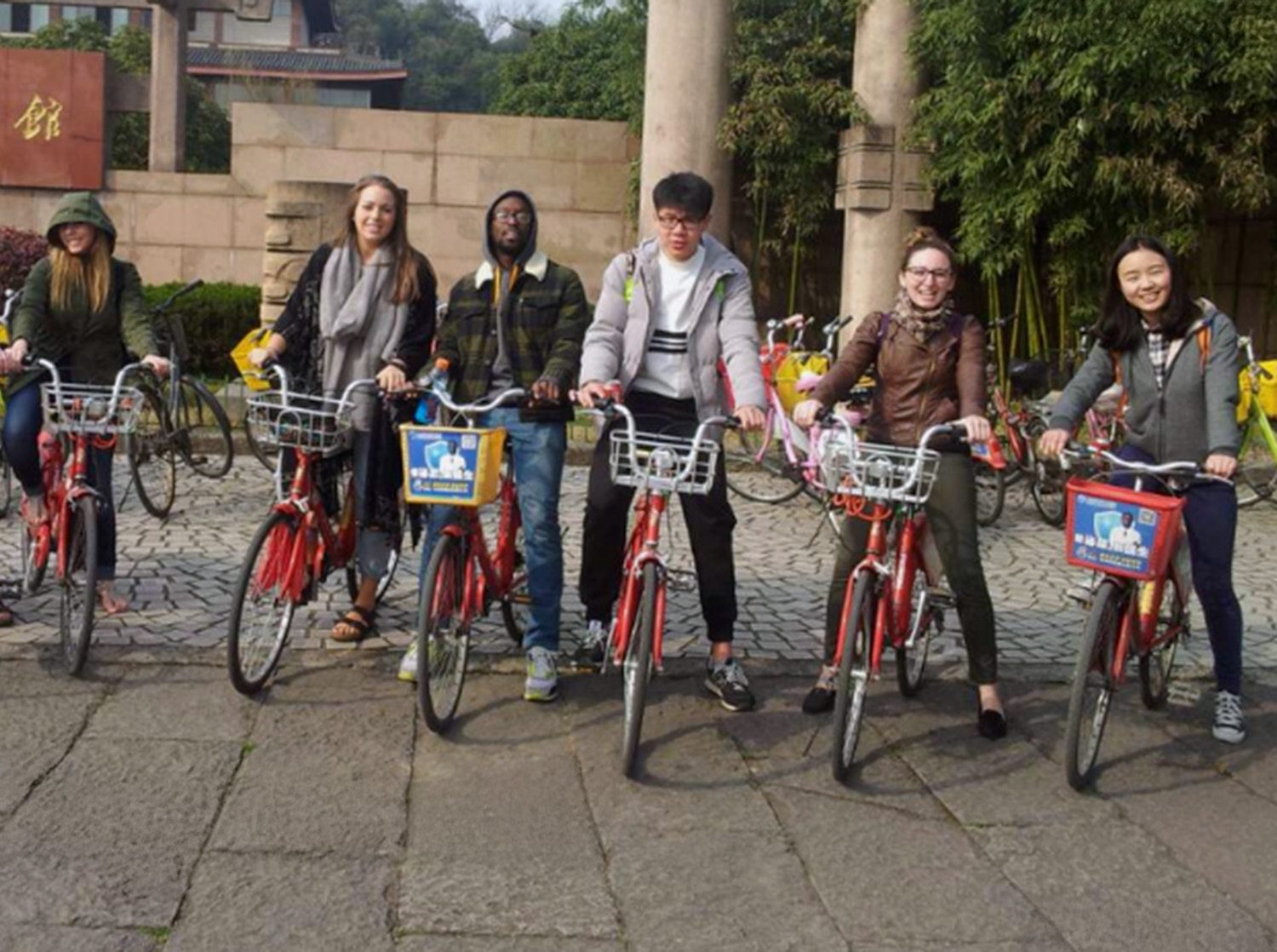 A group of students pose on bicycles