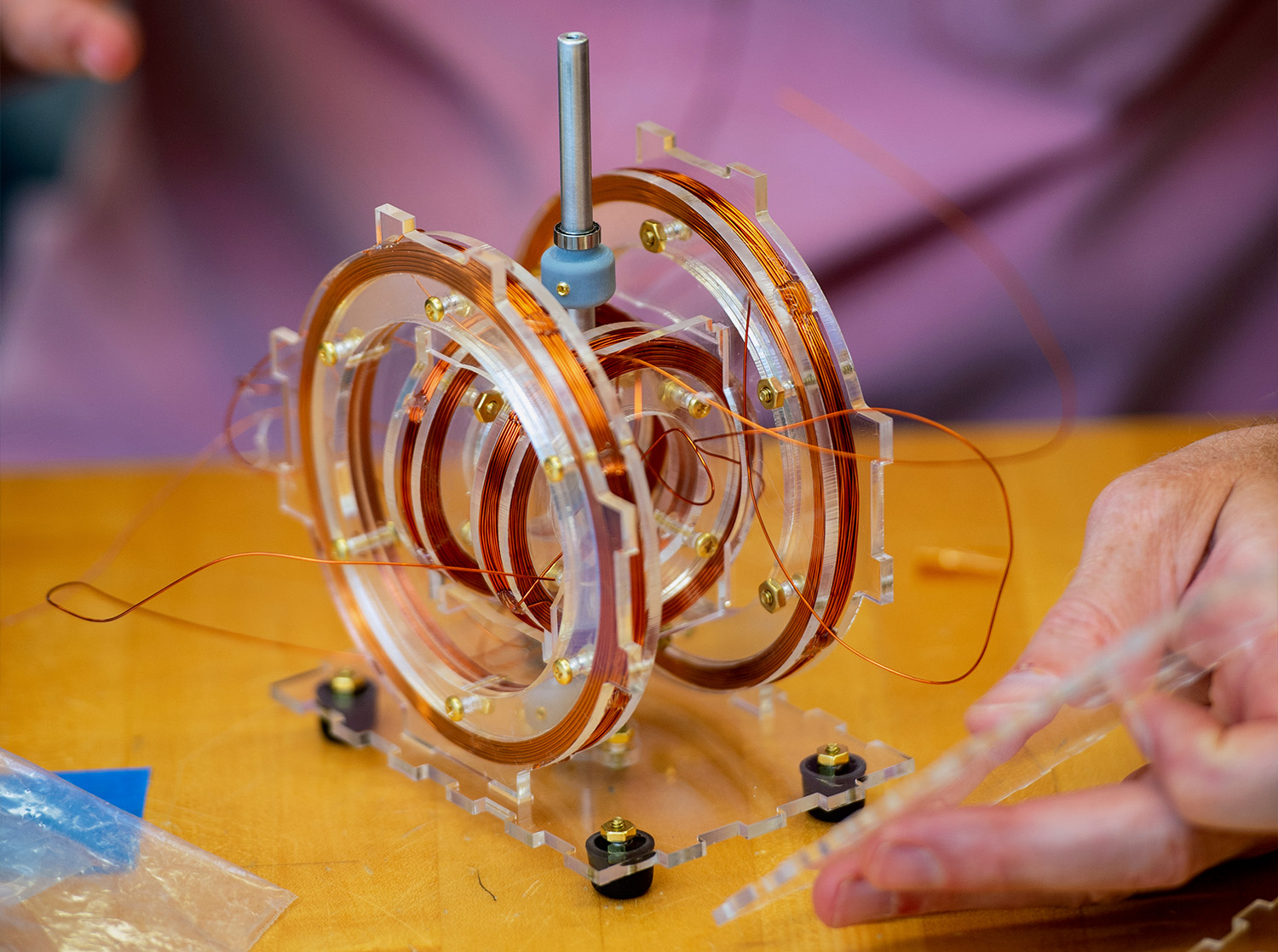 A physics professor conducts an experiment with plastic gears and copper wire
