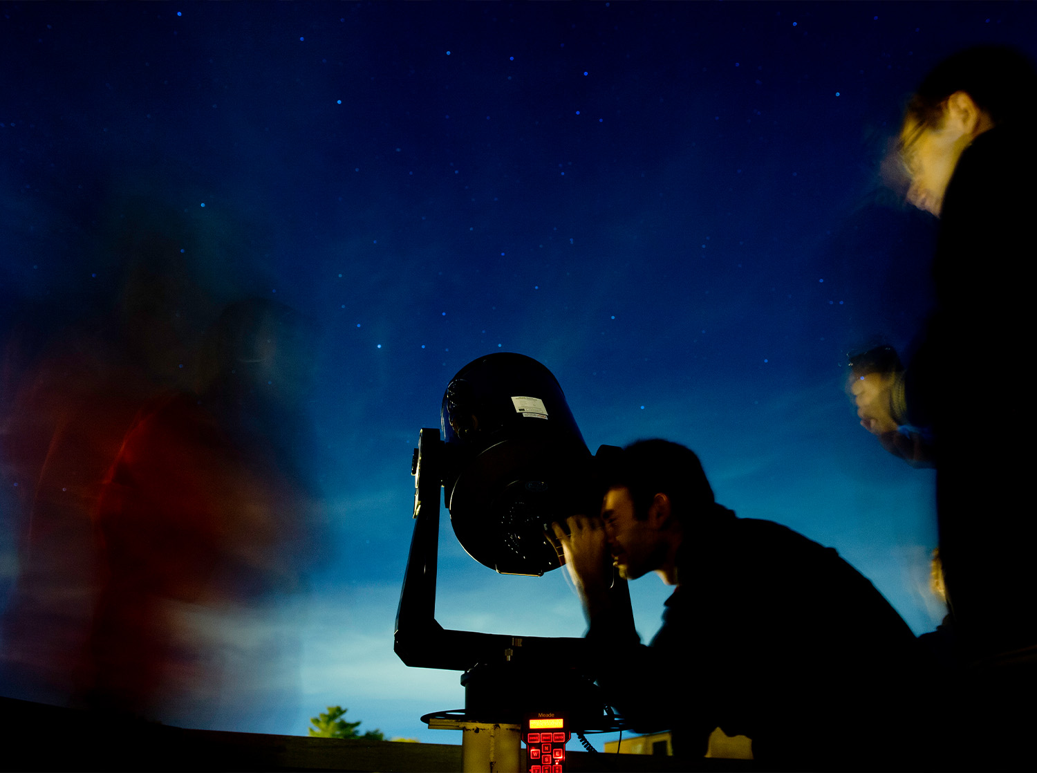 A student looks through a telescope in the campus observatory