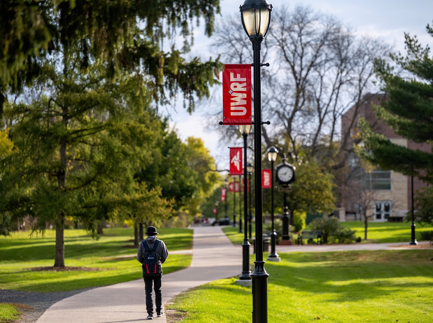 A student walks down a sidewalk on campus