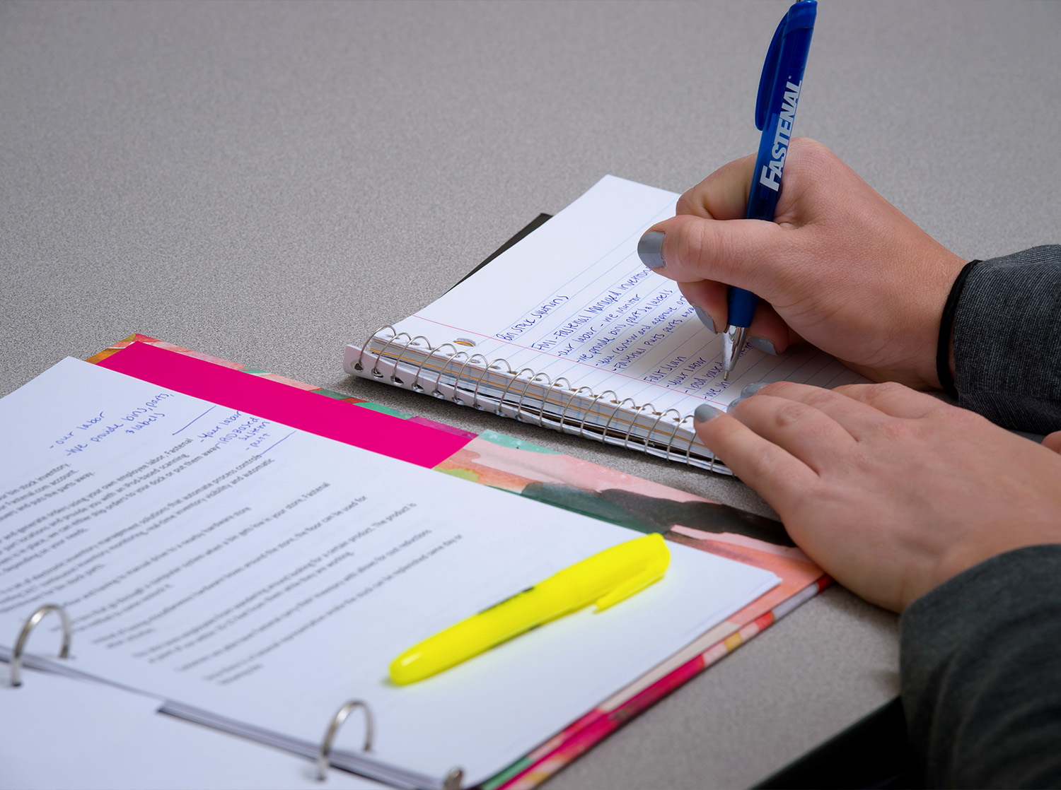 A student writes in a spiral notebook during a sales class