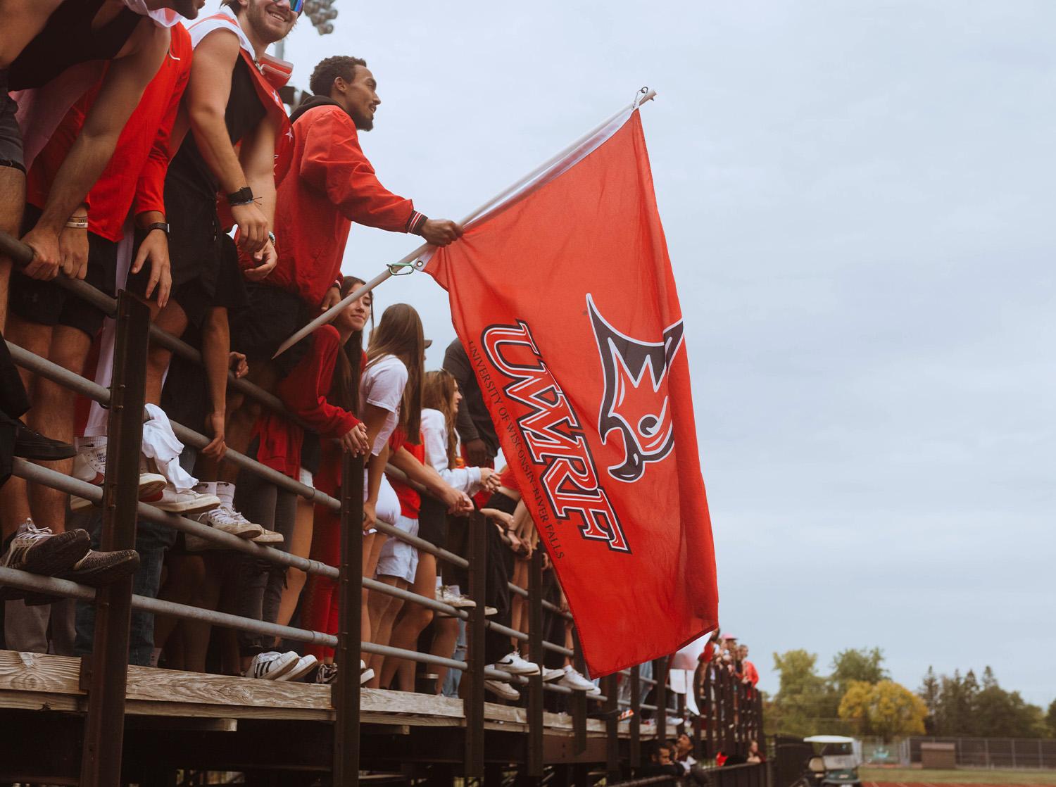 A student waves a UWRF flag during the homecoming football game