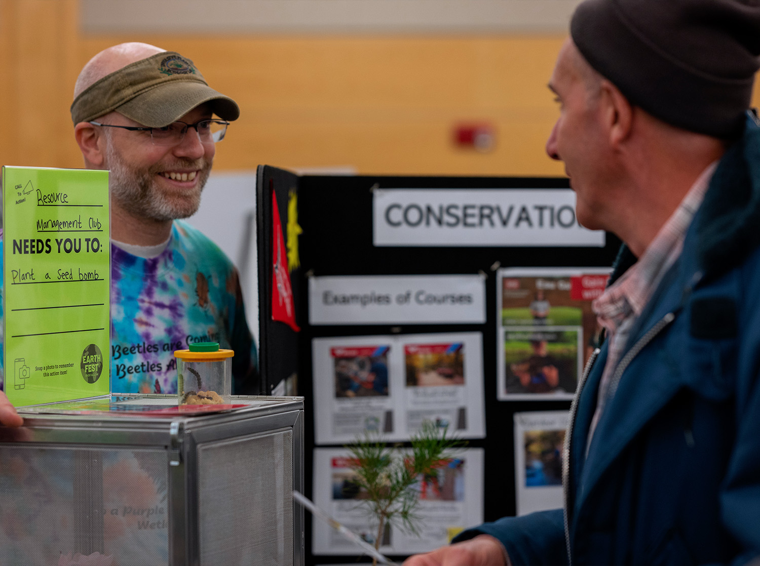 A vendor at the annual Earth Fest talks to a curious community member in the University Center