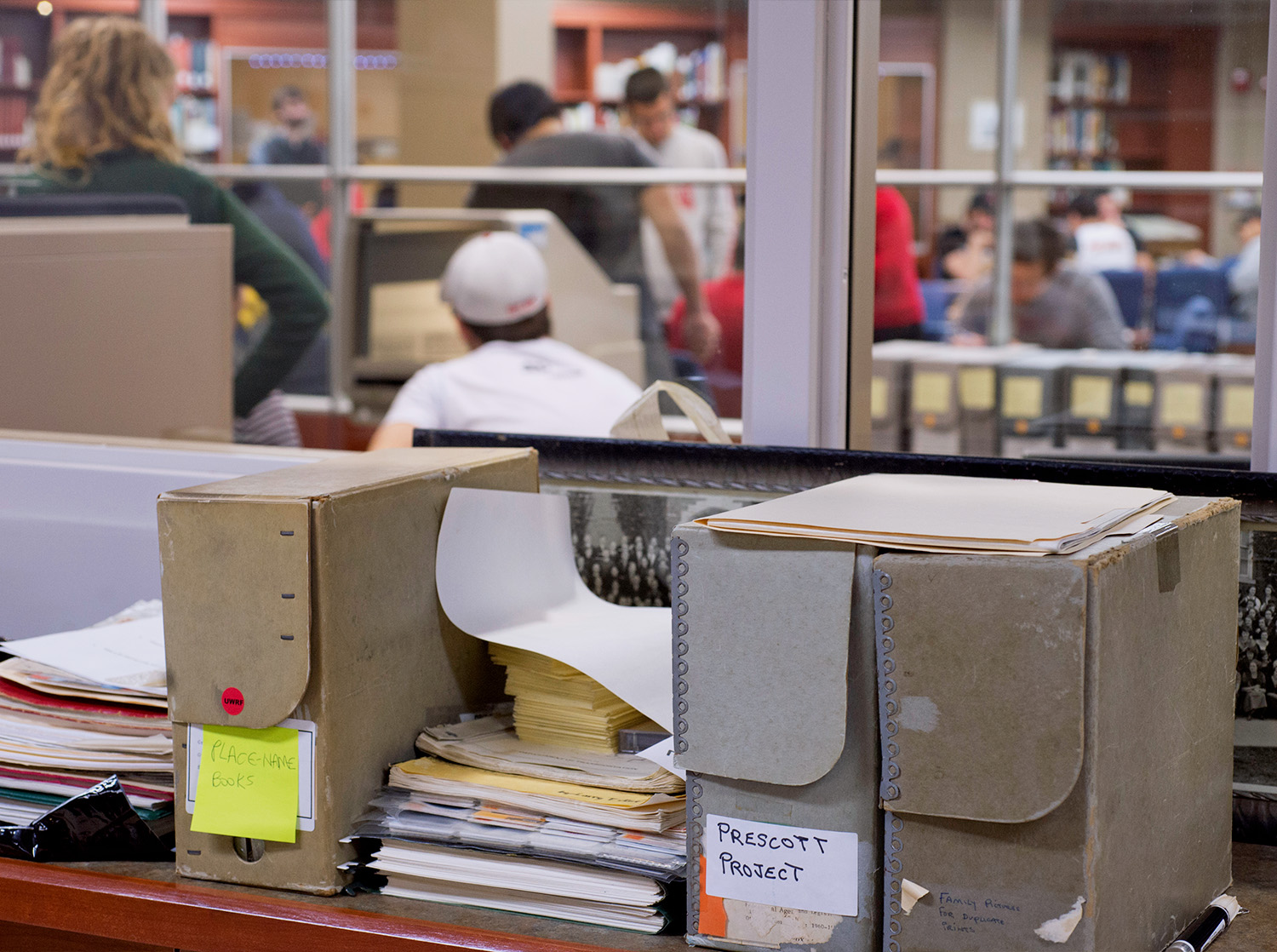 A group of students gather in the library to review material from University Archives