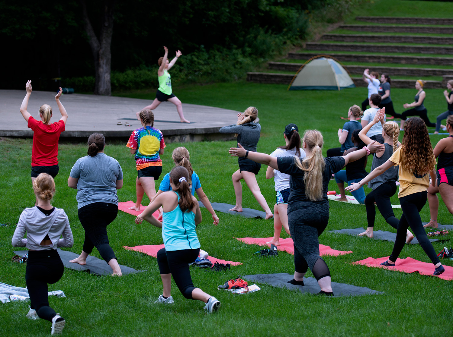A group of women practice yoga at the Melvin Wall Amphitheatre