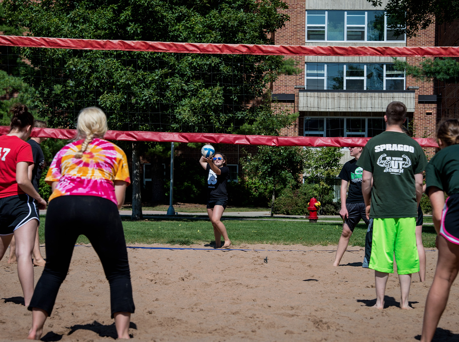 Students participate in a sand volleyball tournament on campus