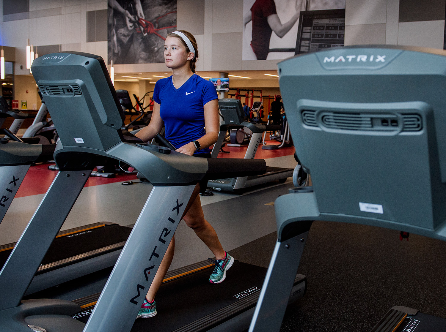 Student walking on a treadmill in the fitness center
