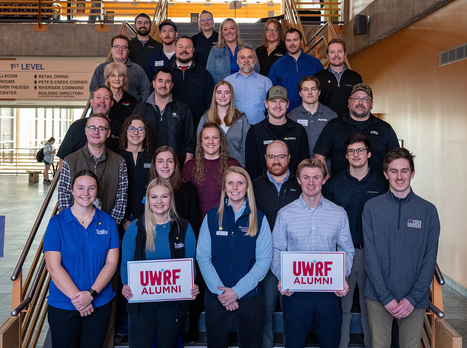 A group of UWRF alumni at the Career Fair pose on the steps in the UC