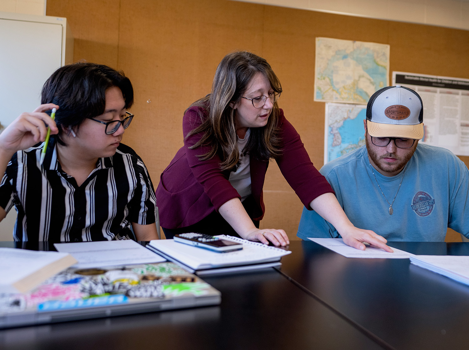 Professor helps two students during an assignment