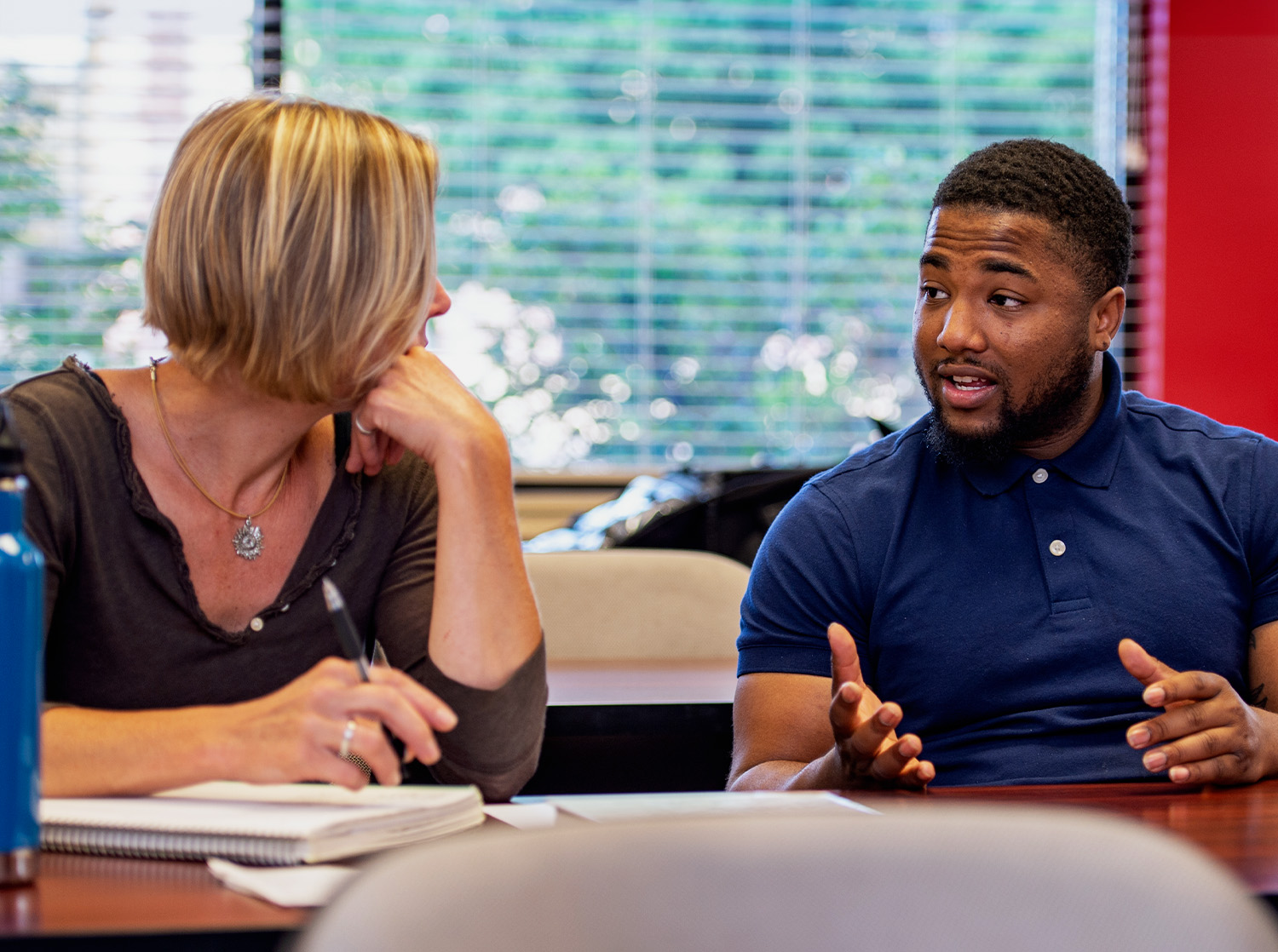 Two graduate students discuss a topic during class