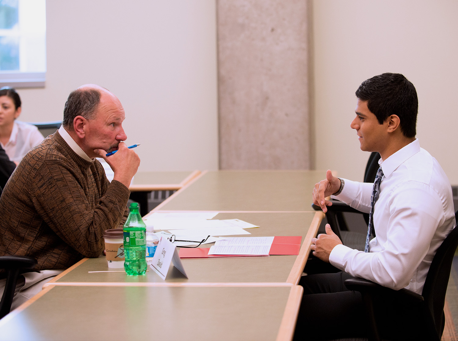 A student participates in a mock interview with a professor