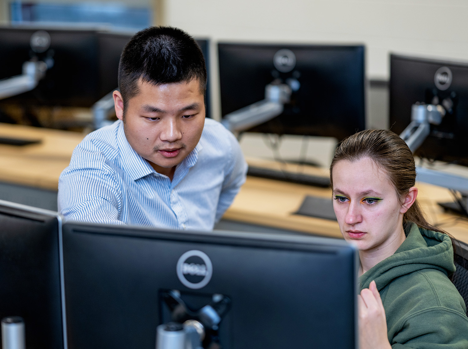 A professor points to a document on a students computer