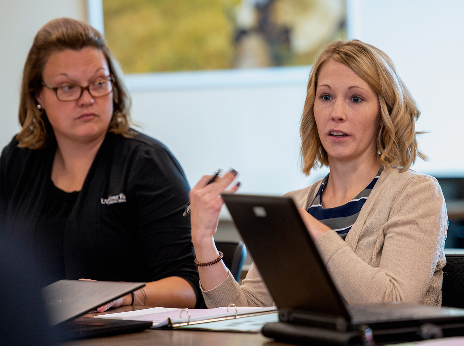 Two faculty members talking during a meeting