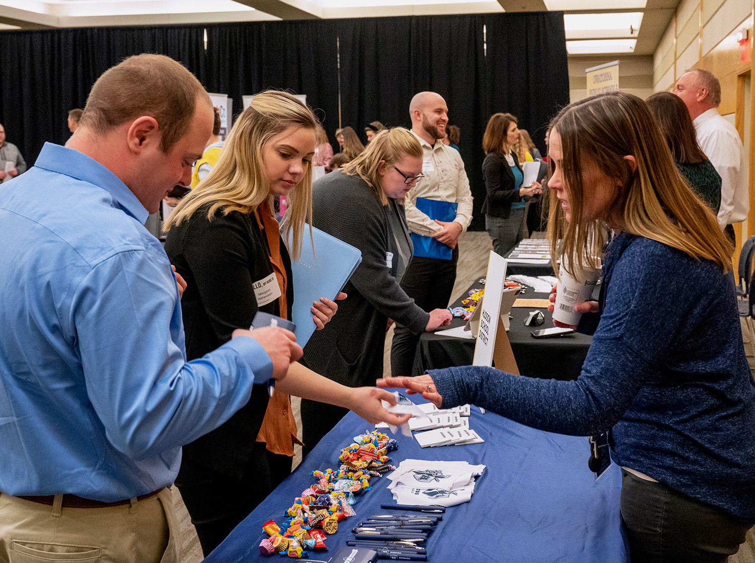 Two students speak with an employer at a booth at the career and internship fair