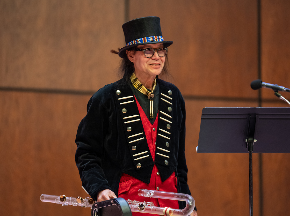 photo of Brent Michael Davids standing on stage holding his instrument.