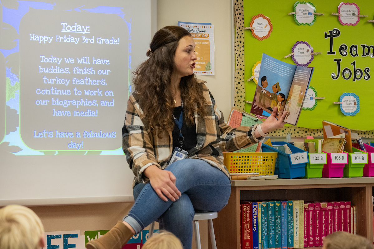 A teacher reads to a classroom