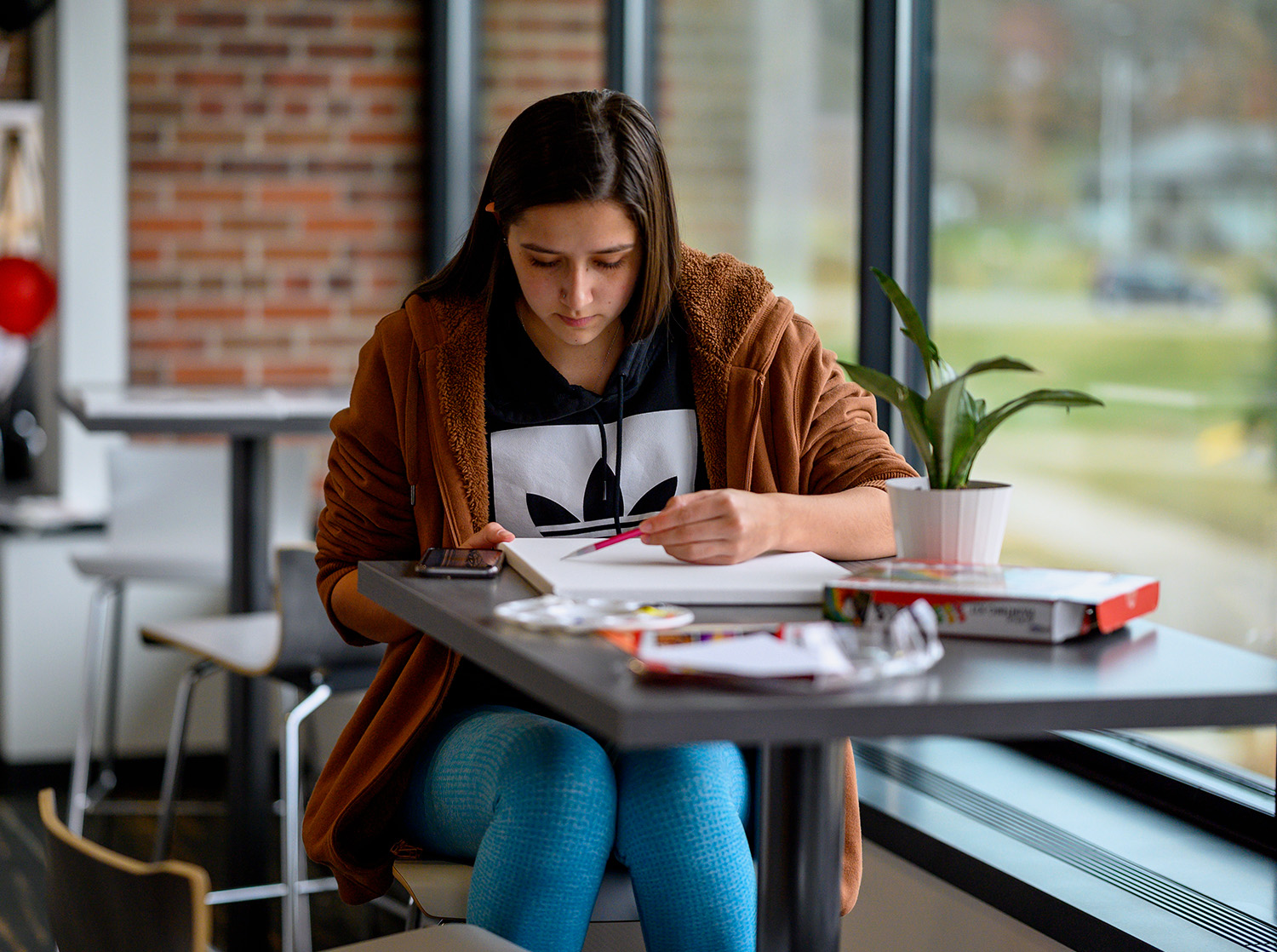 A female student works on an art project in Rodli Hall