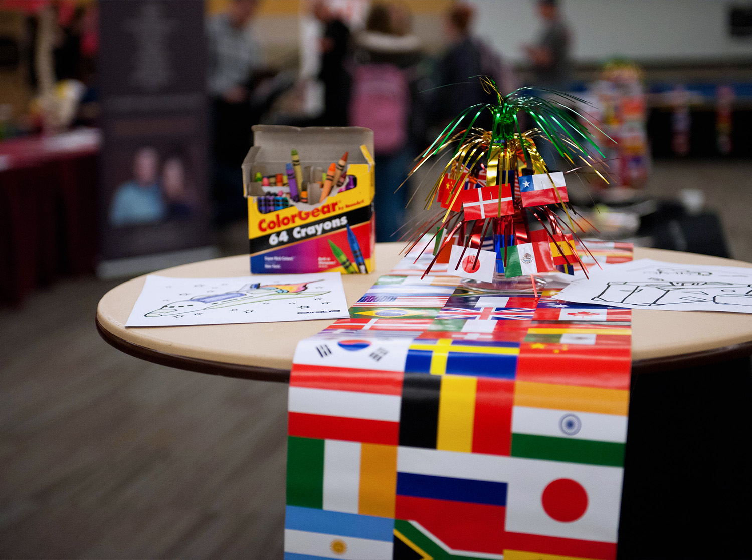 A table covered with a banner of various international flags