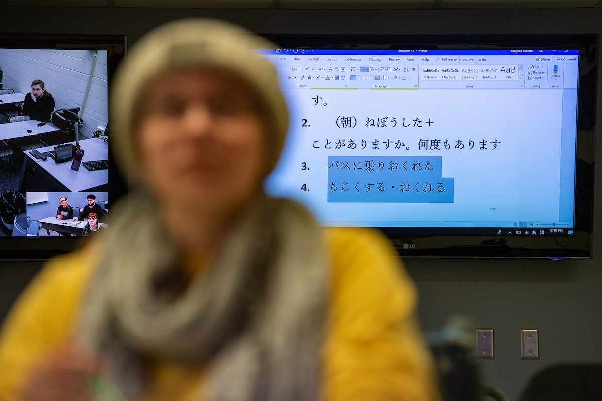 a student sits in front of a screen with information displayed