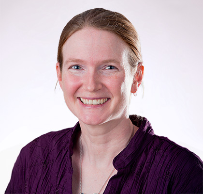 Headshot of Jill Coleman Wasik, a woman with brown hair and wearing a purple blouse