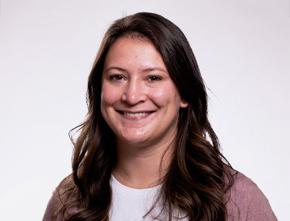 Headshot of Kaelyn White.  A woman with long dark brown hair and a light pink cardigan