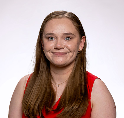 Headshot of Katelyn Pearson, a young woman with long brown hair with a bright red tank top