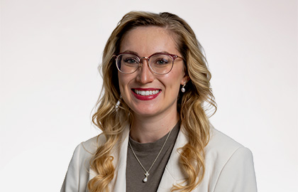 Headshot of Kathryn Lostocco, a young woman with long brown blonde hair and tan round glasses.